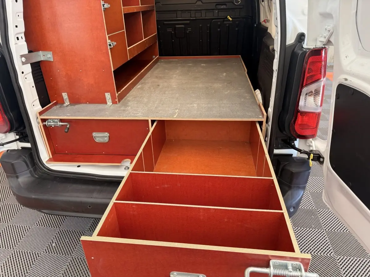 Vue arrière du Citroën Berlingo blanc 2019 avec aménagements en bois rouge et tiroirs ouverts dans la zone de chargement.