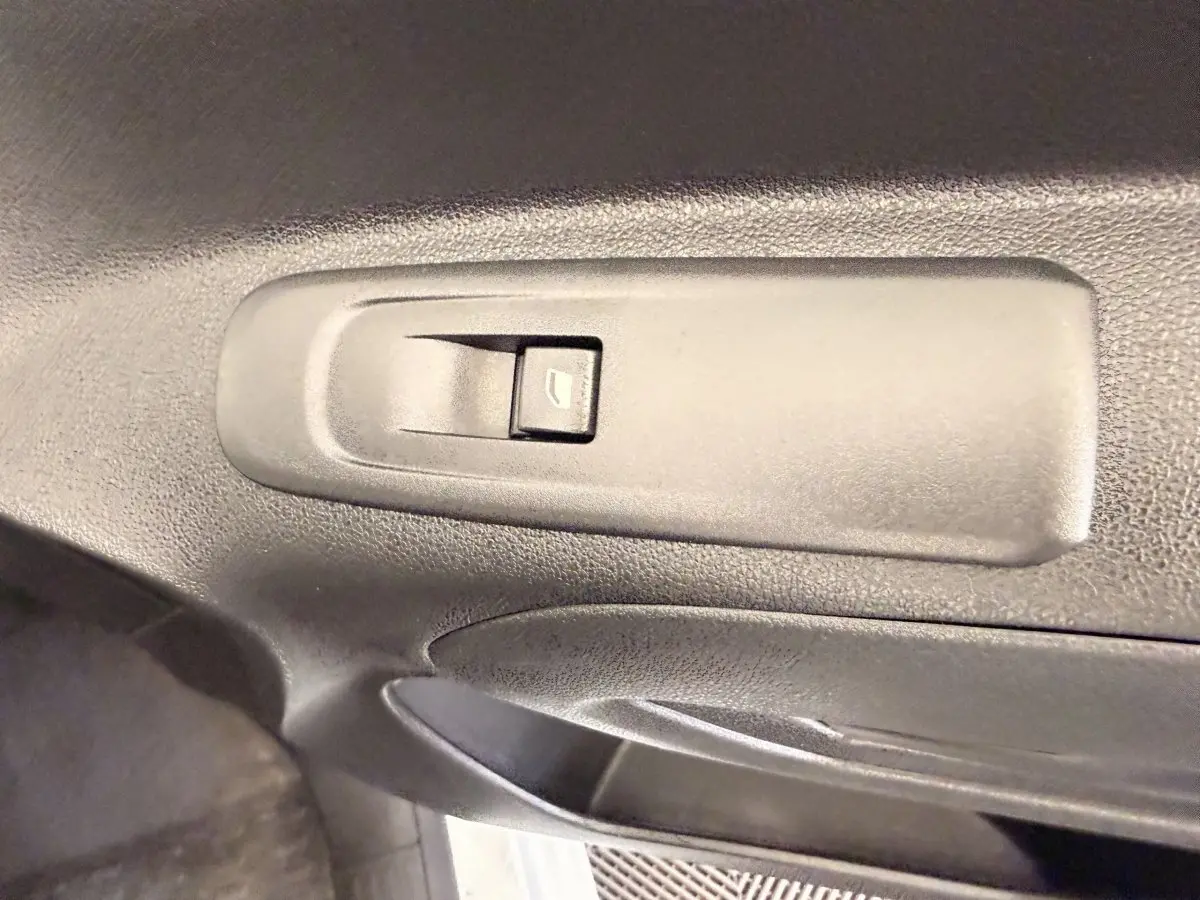 Gros plan sur le bouton de commande de la vitre électrique côté conducteur du Citroën Berlingo blanc de 2019.