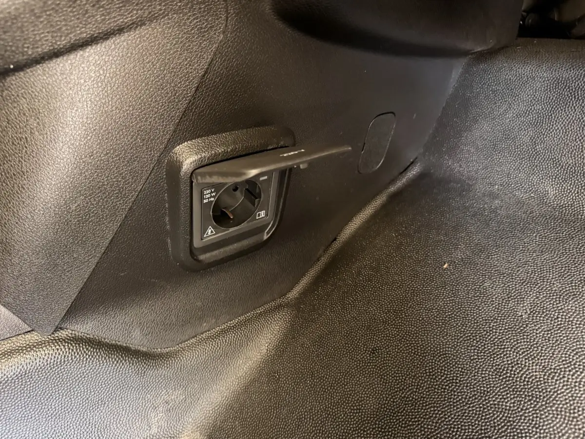 Prise électrique 220V intégrée dans l’espace de chargement du Citroën Berlingo blanc de 2019, vue intérieure côté droit.