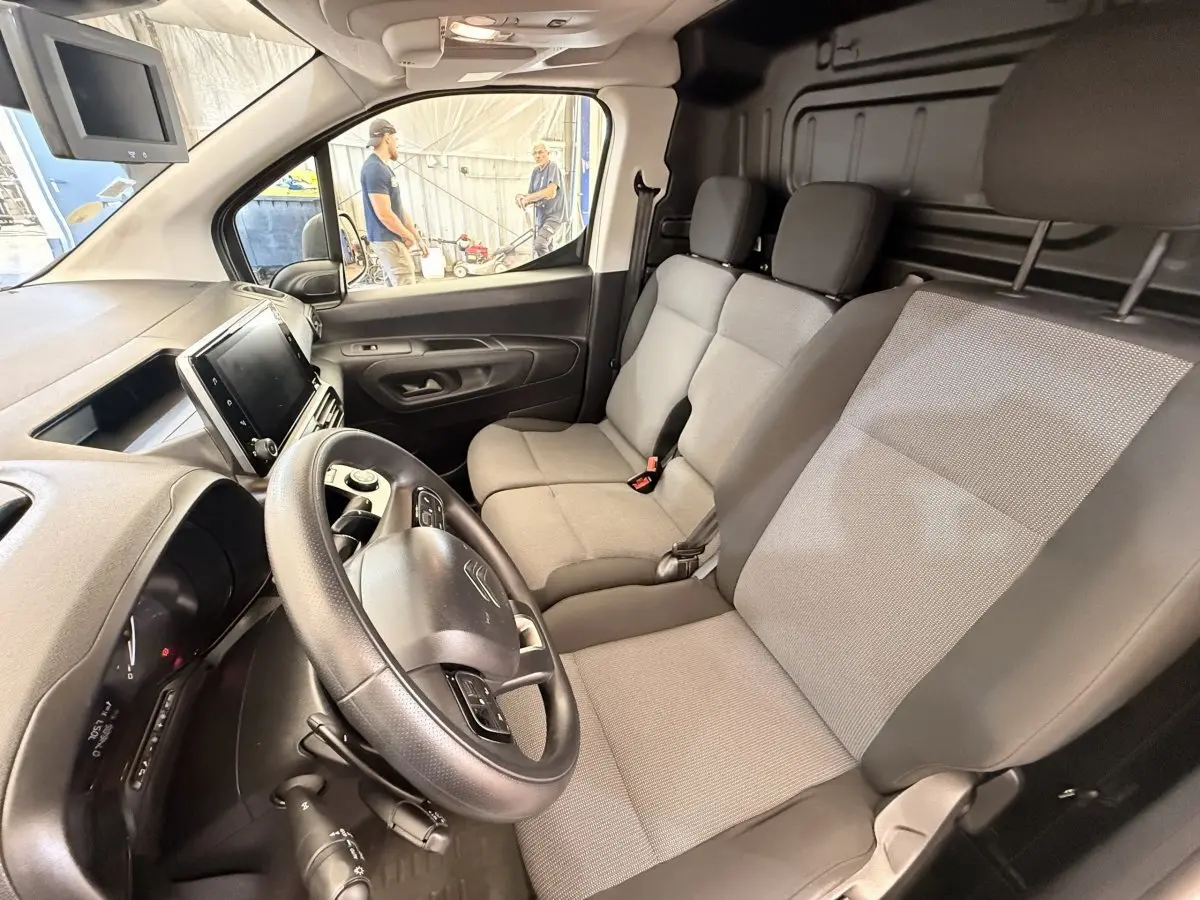 Vue intérieure côté conducteur du Citroën Berlingo 2019, sièges gris et tableau de bord avec écran tactile.