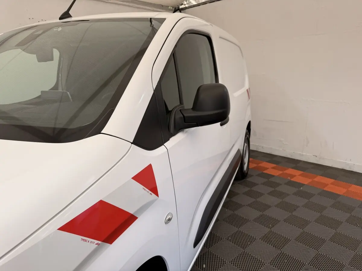 Vue 3/4 avant droit d’un Citroën Berlingo blanc 2019 avec bandes rouges diagonales sur l’aile avant.
