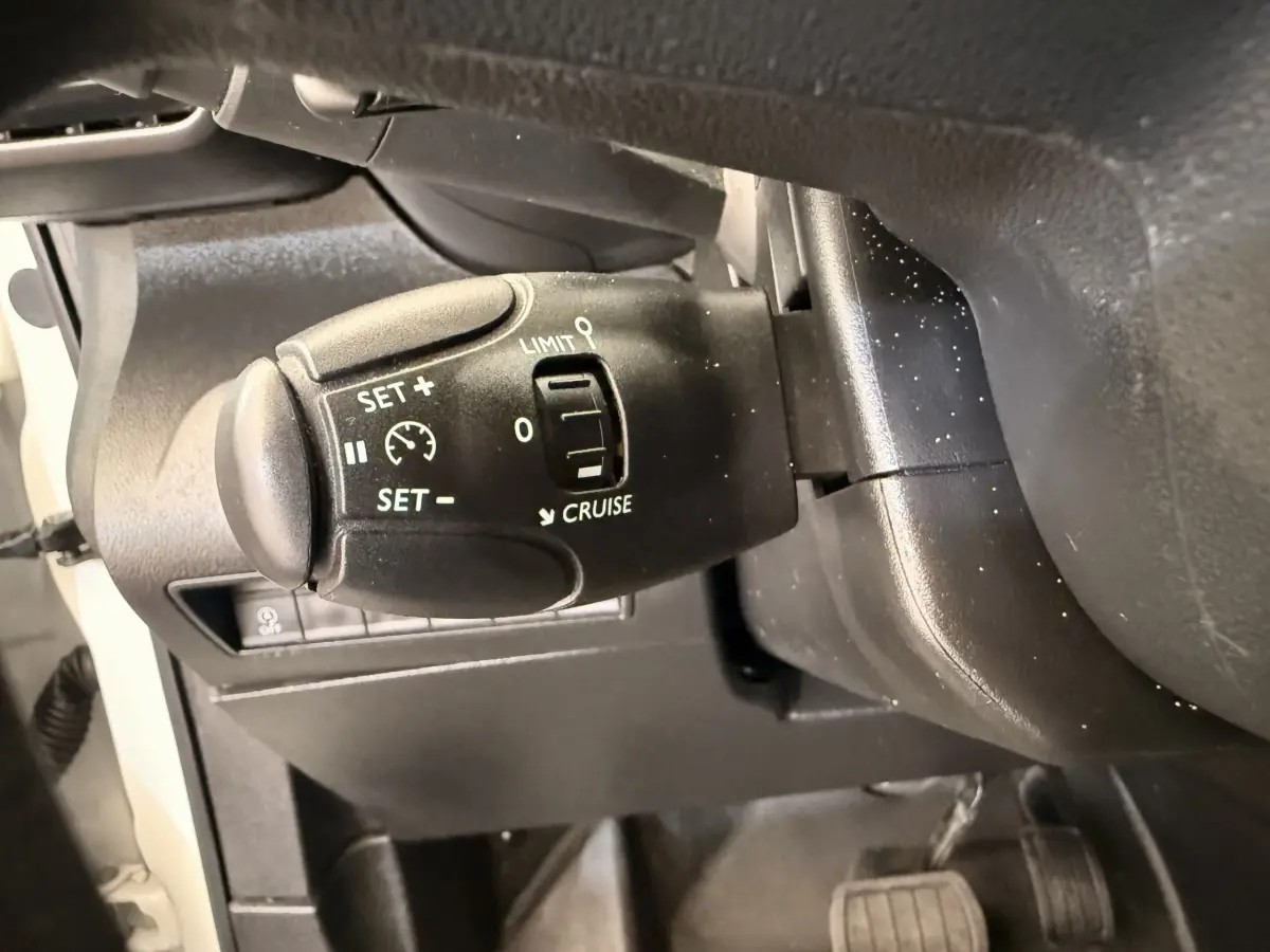 Gros plan sur le commodo de régulateur de vitesse du Citroën Berlingo 2019, intérieur noir avec commandes blanches.