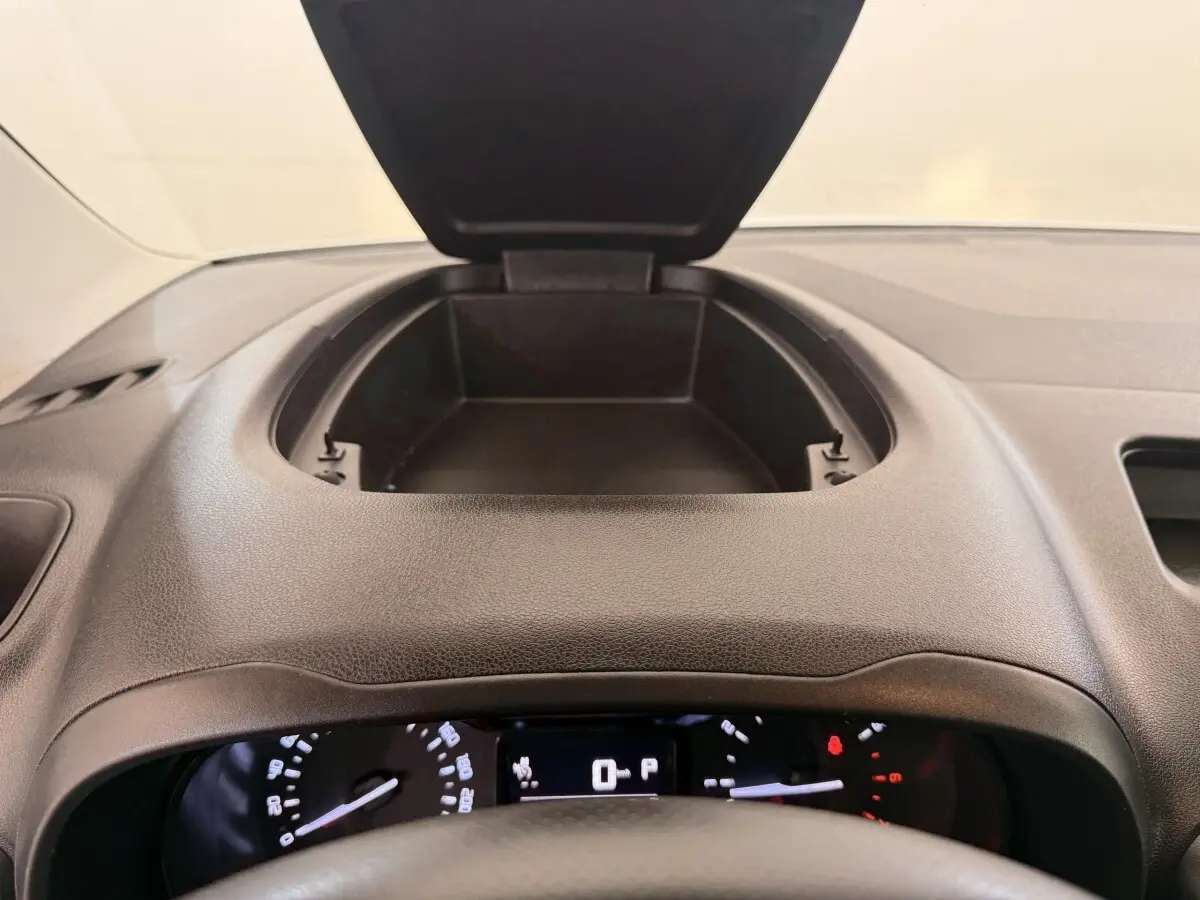 Vue intérieure du tableau de bord noir du Citroën Berlingo 2019, avec rangement ouvert au centre et compteurs visibles.