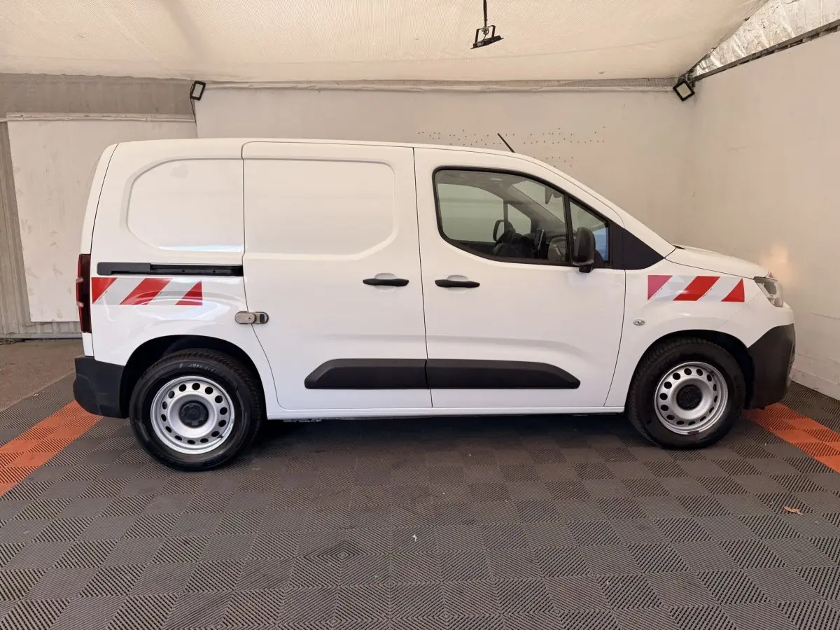 Vue de profil côté droit d'un Citroën Berlingo blanc 2019 avec bandes réfléchissantes rouges sur ailes avant et arrière.
