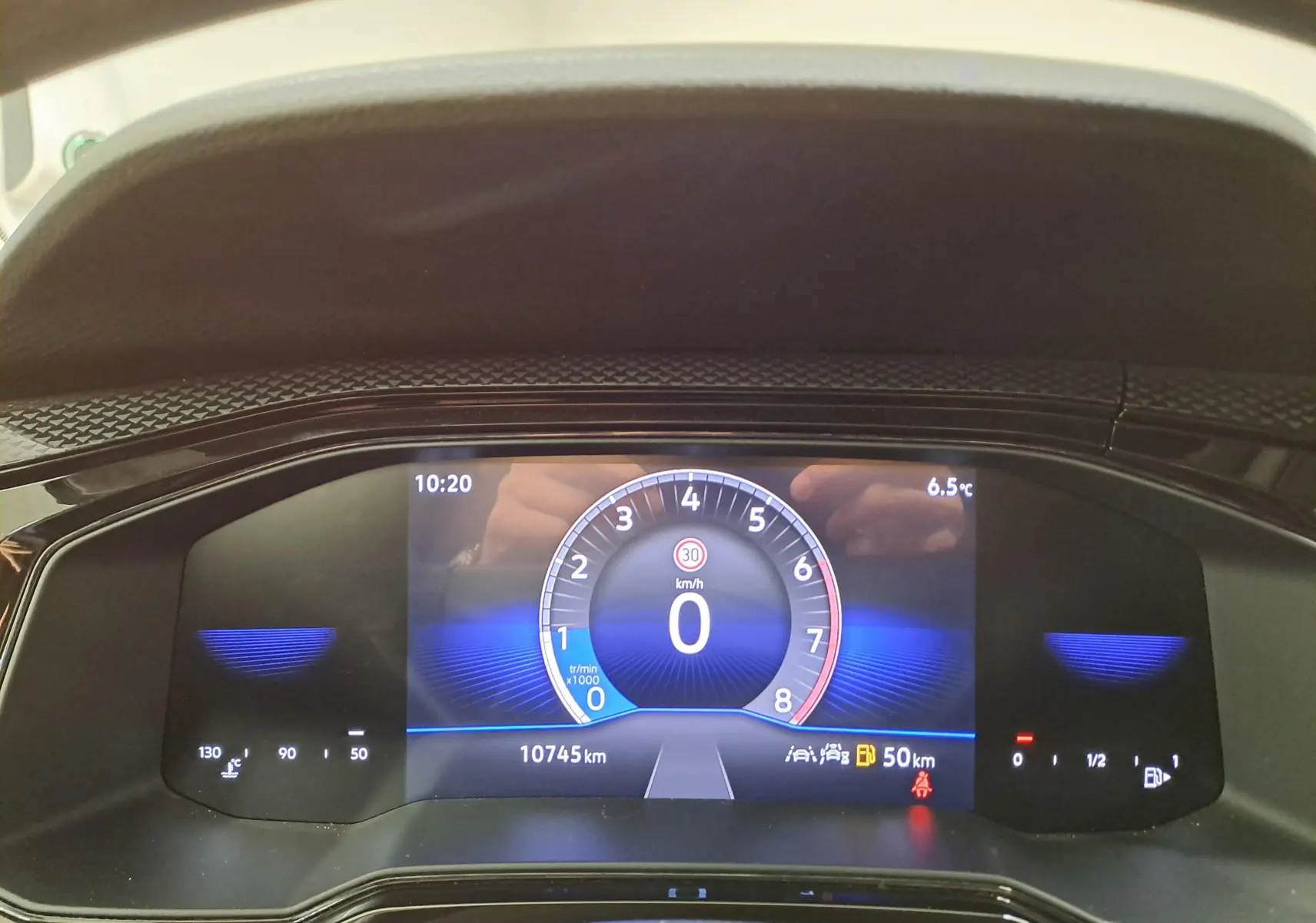 Vue rapprochée du tableau de bord numérique du Volkswagen Taigo 2024 affichant la vitesse à 0 km/h et 10 745 km au compteur.