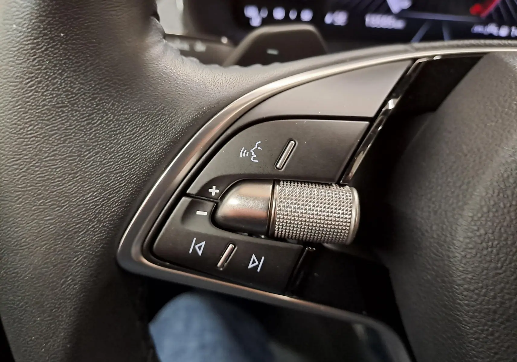 Gros plan sur les commandes vocales et multimédia au volant d’un Skoda Scala gris graphite 2025.