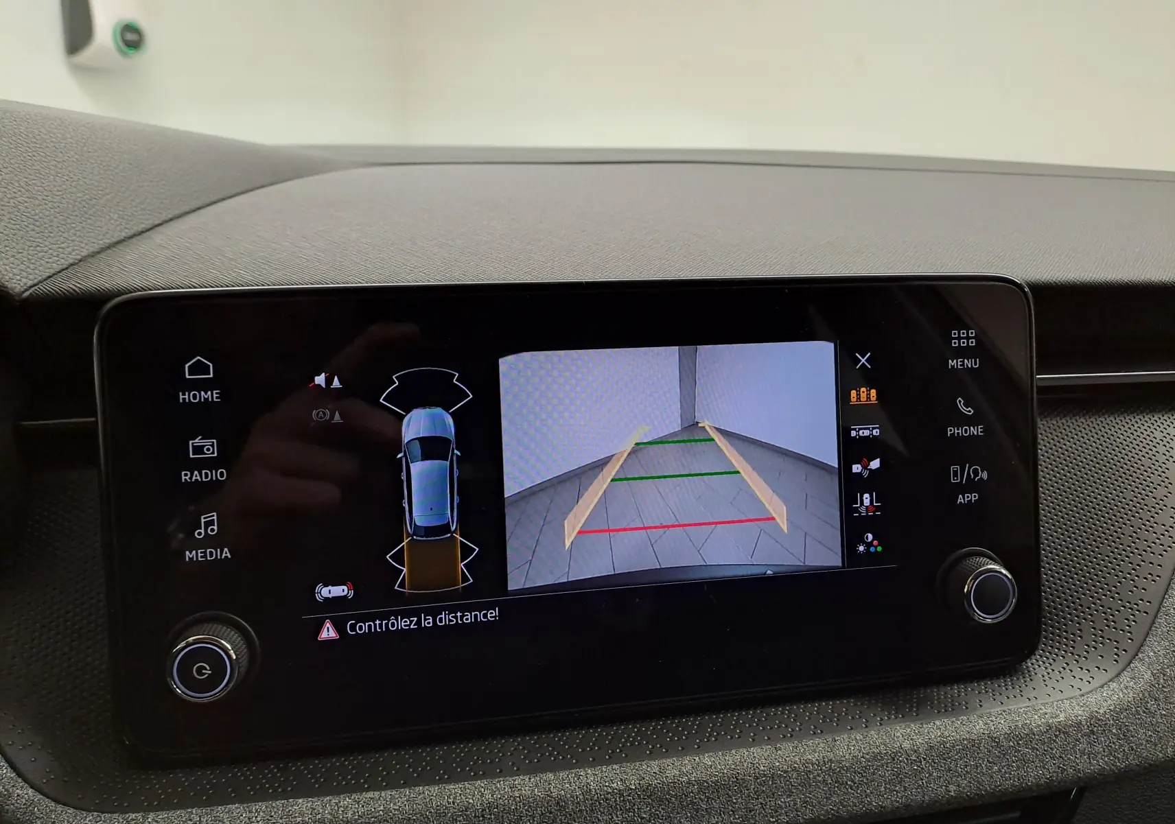 Écran central de la Skoda Scala 2025 montrant la caméra de recul avec guidage de trajectoire en intérieur noir.