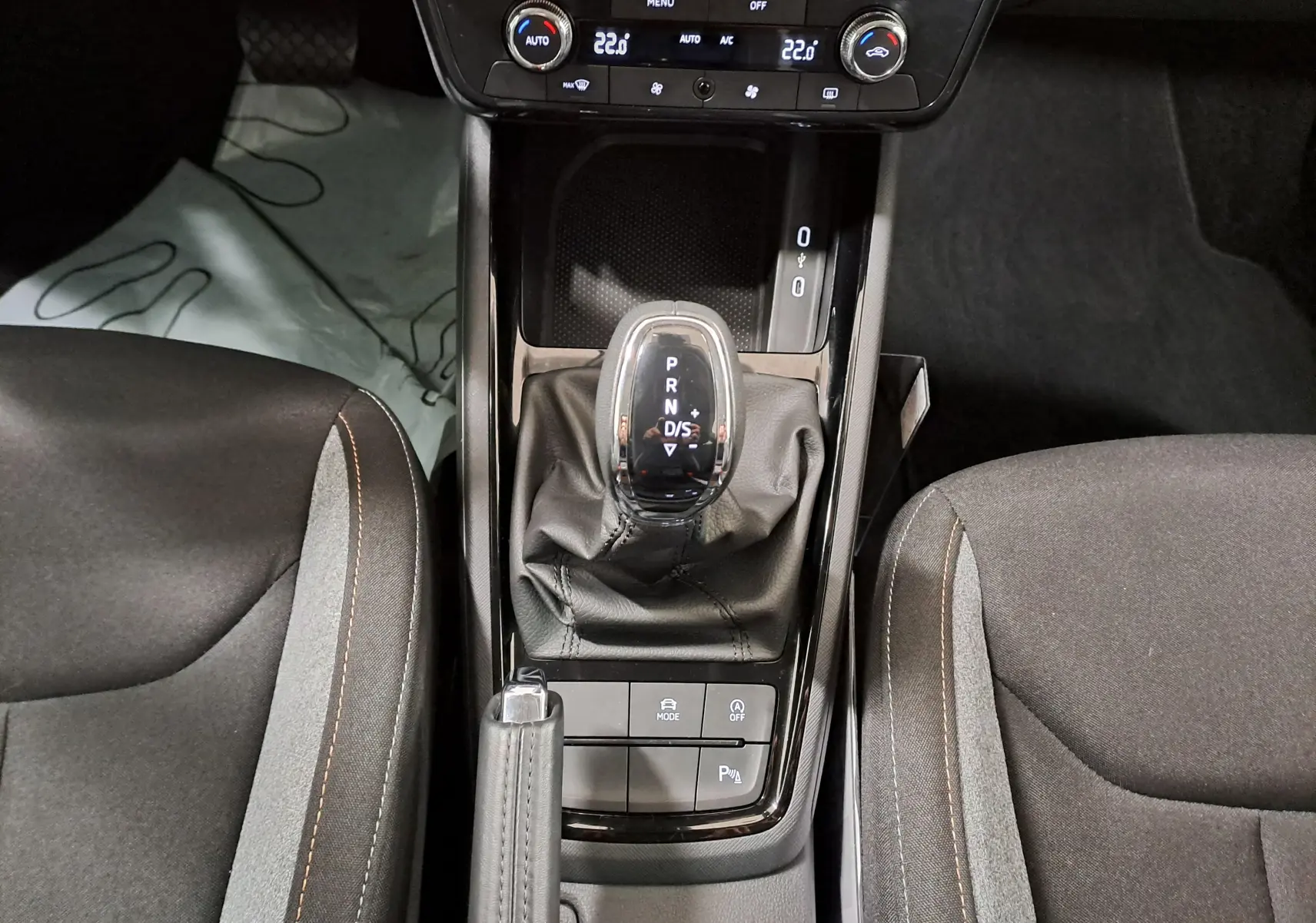 Vue plongeante sur la console centrale de la Skoda Scala gris graphite 2025, avec levier de vitesse automatique et commandes climatisation.