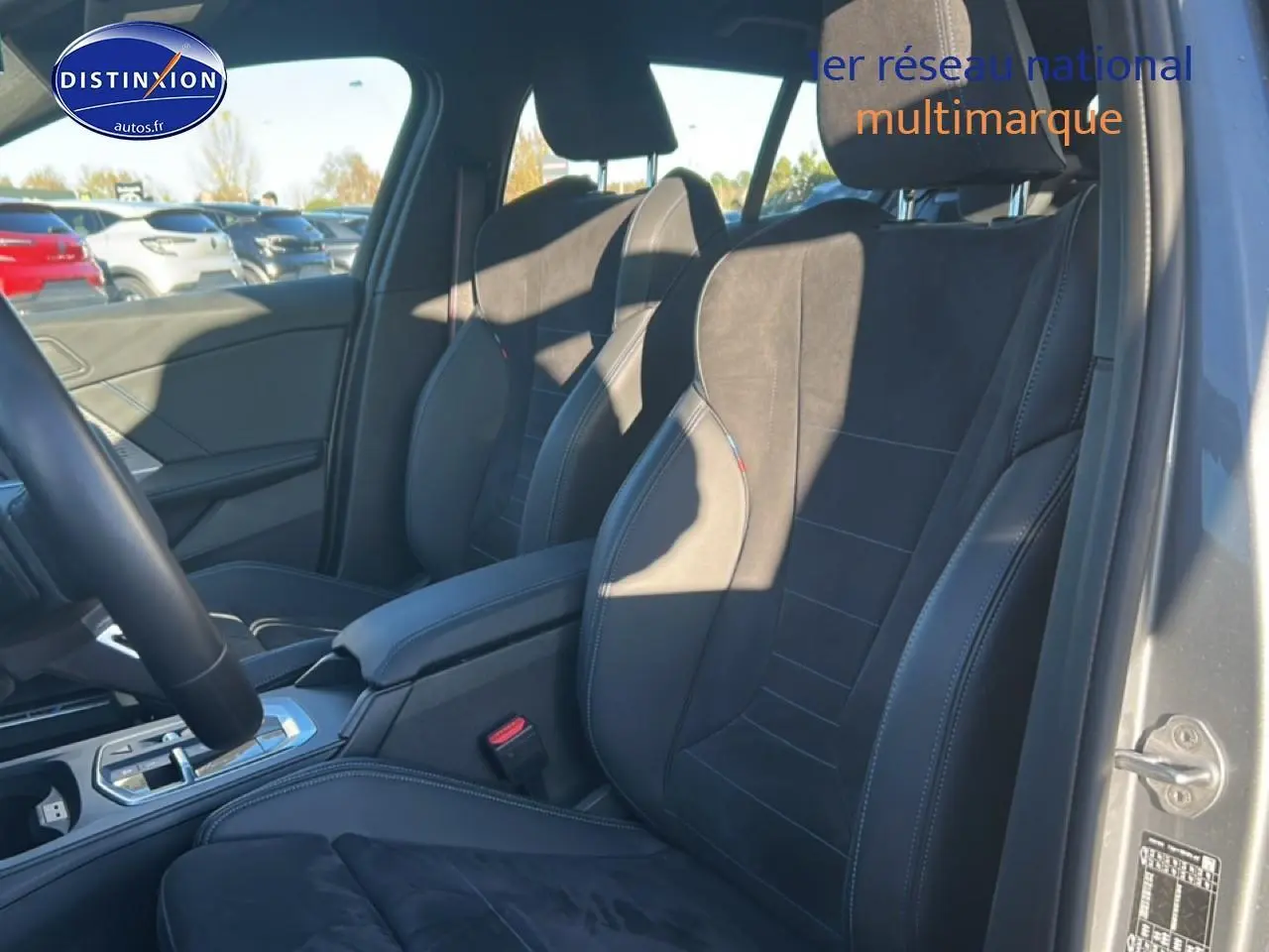 Vue intérieure côté droit sur les sièges sport en tissu alcantara noir avec surpiqûres bleues d'une BMW Série 1 gris Skyscraper.