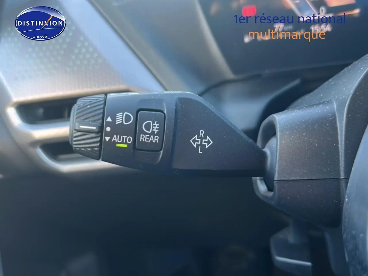 Gros plan sur la commande des phares et clignotants à gauche du volant dans une BMW Série 1 gris Skyscraper.