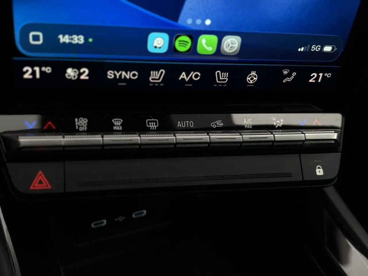 Gros plan sur la console centrale du Renault Rafale 4x4 E-Tech bleu sommet, avec commandes climatisation et écran tactile.