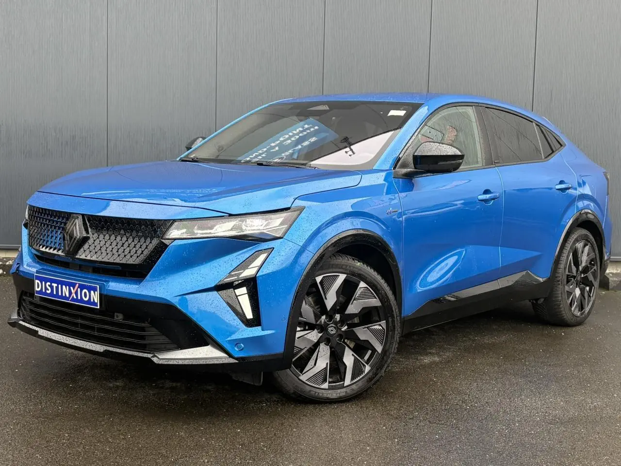 Renault Rafale 4x4 E-Tech bleu sommet en 3/4 avant droit, calandre noire et jantes alliage diamantées noires.