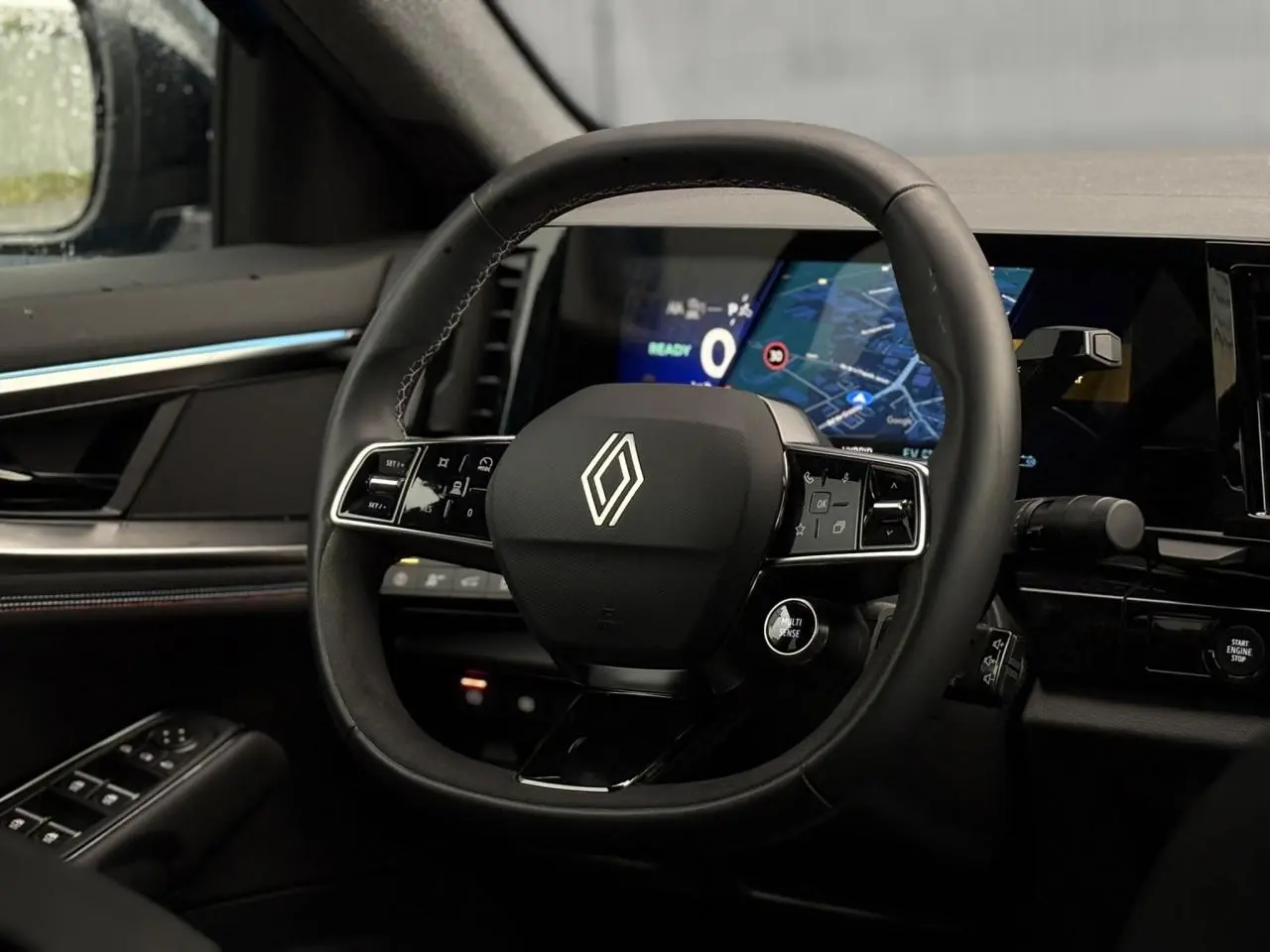 Vue intérieure centrée sur le volant noir de la Renault Rafale 2025 avec tableau de bord numérique et commandes intégrées.