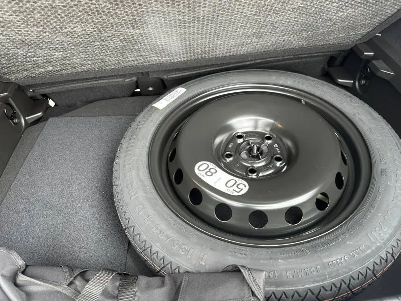 Vue rapprochée de la roue de secours noire dans le coffre du Renault Captur 2026 gris Rafale/Noir Étoilé.