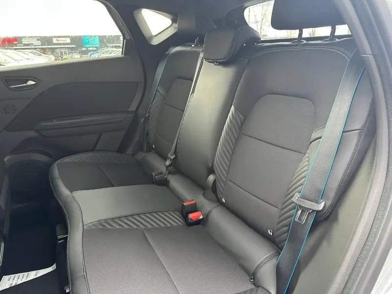 Vue intérieure côté droit des sièges arrière noirs avec surpiqûres bleues du Renault Captur 1.8 E-Tech full hybrid 2026.