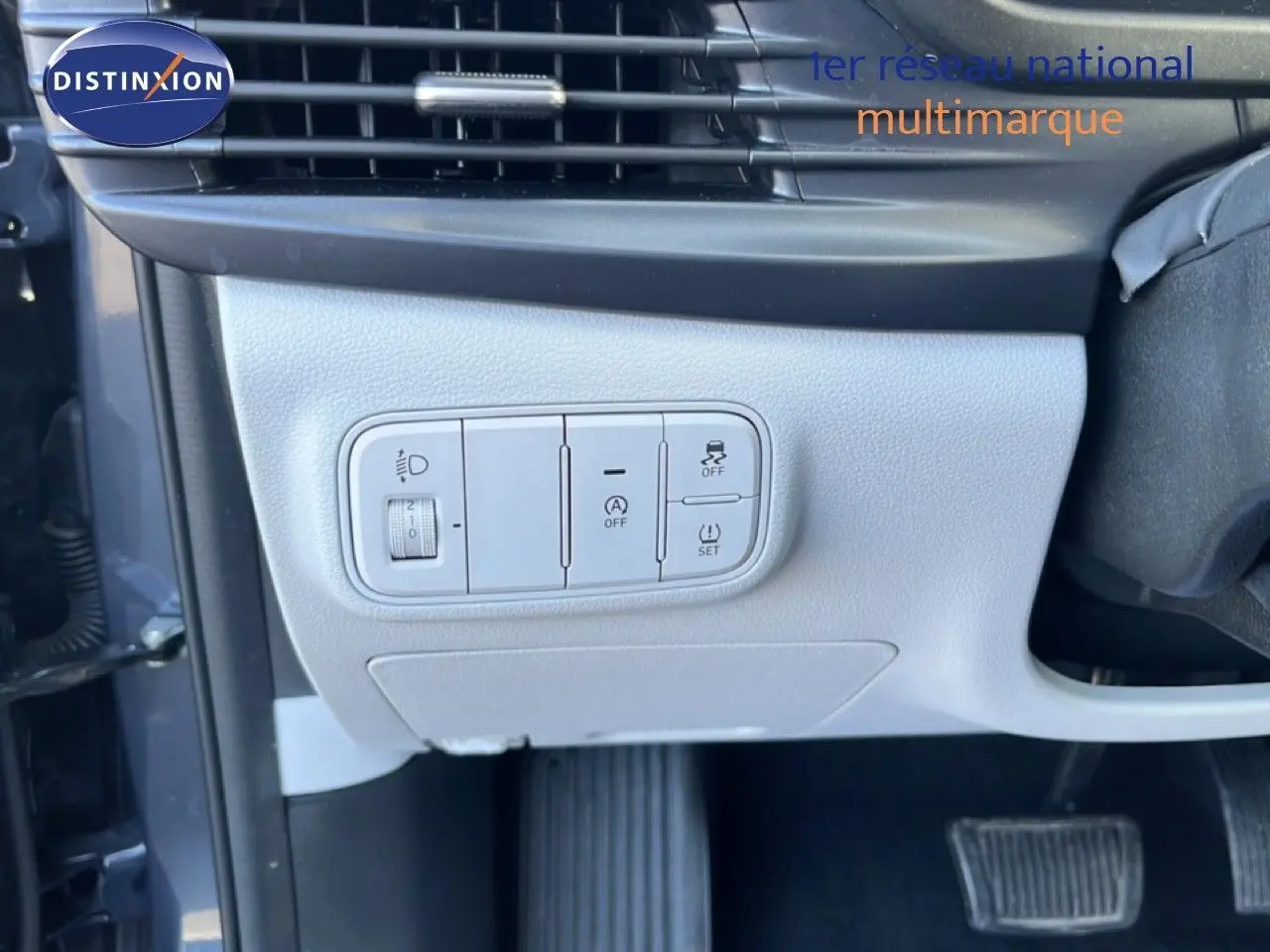 Gros plan sur les commandes de réglage d’éclairage et d’assistance côté gauche d’un Hyundai i20 gris Aurora Metal 2025.