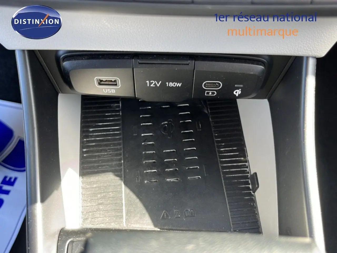 Gros plan sur la console centrale de la Hyundai i20 2025, montrant le chargeur sans fil et les ports USB et 12V.