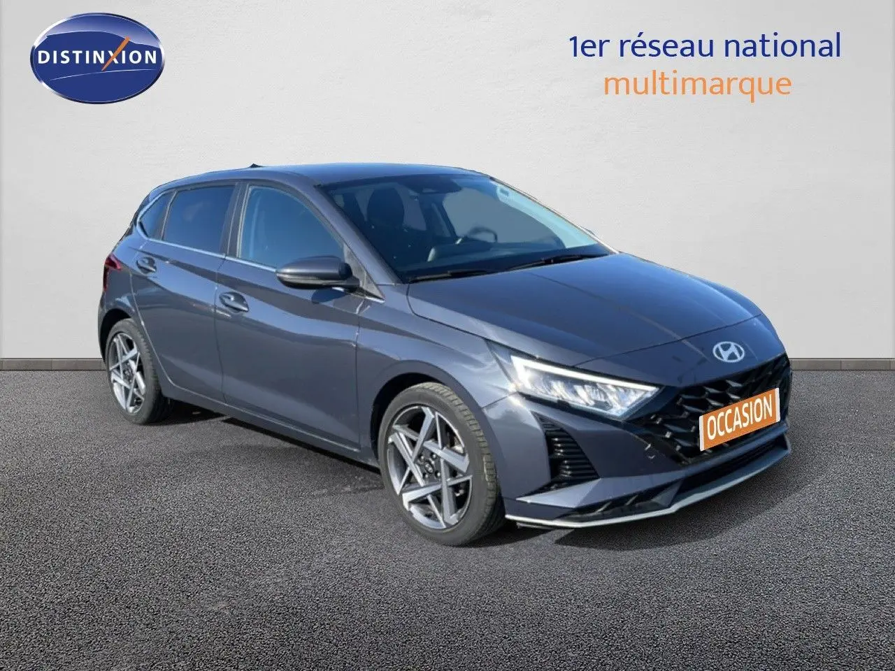 Vue 3/4 avant droite d'une Hyundai i20 gris Aurora Metal avec jantes alliage et calandre noire distinctive.