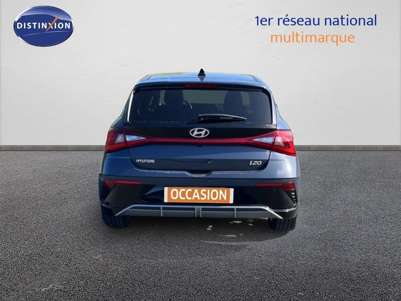 Vue arrière d'une Hyundai i20 gris aurora metal avec feux arrière en bandeau lumineux et plaque "OCCASION".