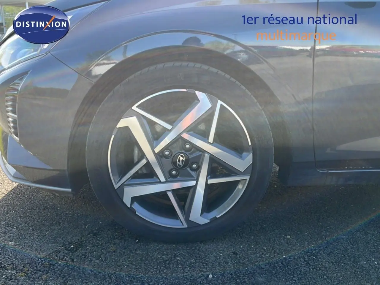 Gros plan sur la roue avant gauche d’une Hyundai i20 gris Aurora Metal avec jante alliage au design géométrique.