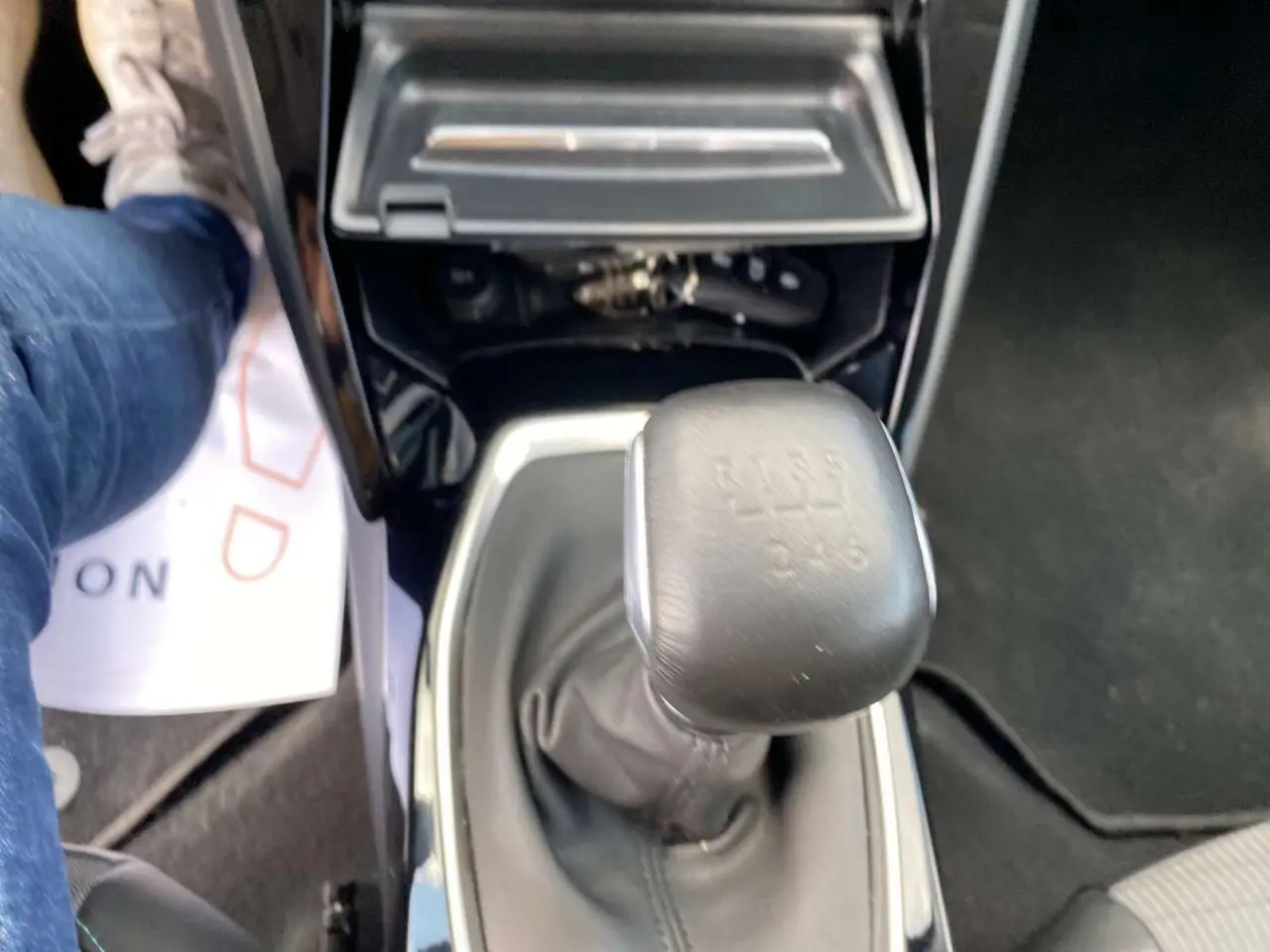 Vue rapprochée du levier de vitesses manuel noir de la Peugeot 208 2021, avec console centrale brillante autour.
