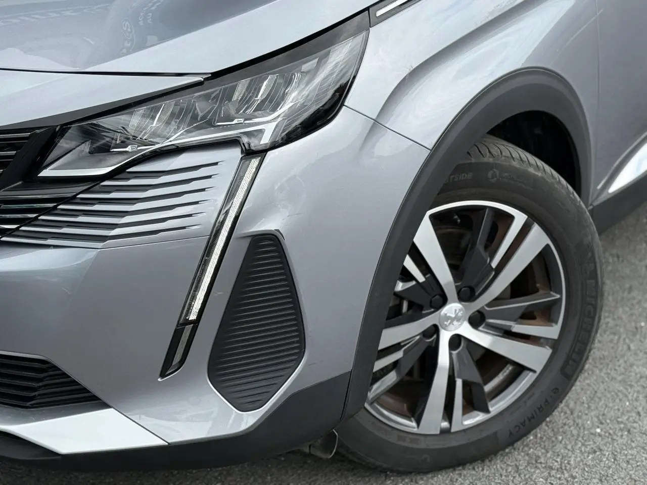 Gros plan sur l'avant droit gris Artense du Peugeot 3008 2024, avec projecteur LED et jante alliage 18 pouces.