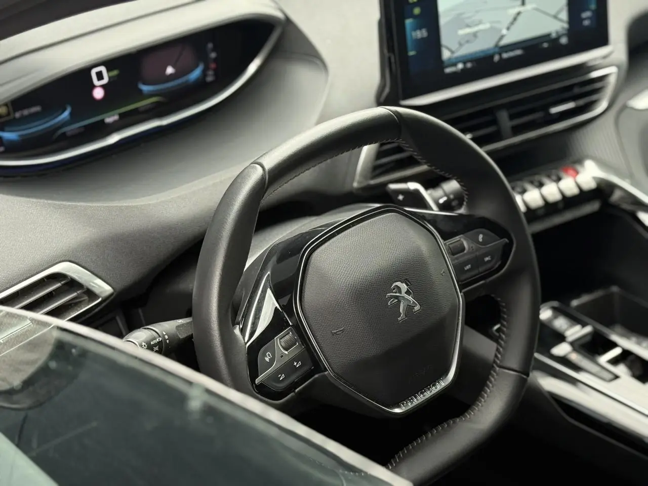 Vue intérieure du volant compact Peugeot 3008 2024 avec tableau de bord numérique et écran tactile central.