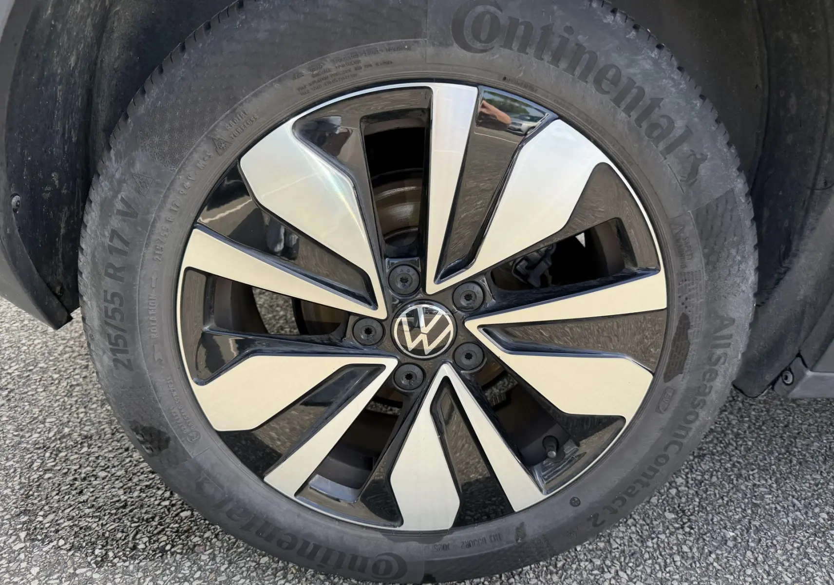 Gros plan sur la jante alliage bicolore d’un Volkswagen T-Roc gris, avec pneu Continental visible.