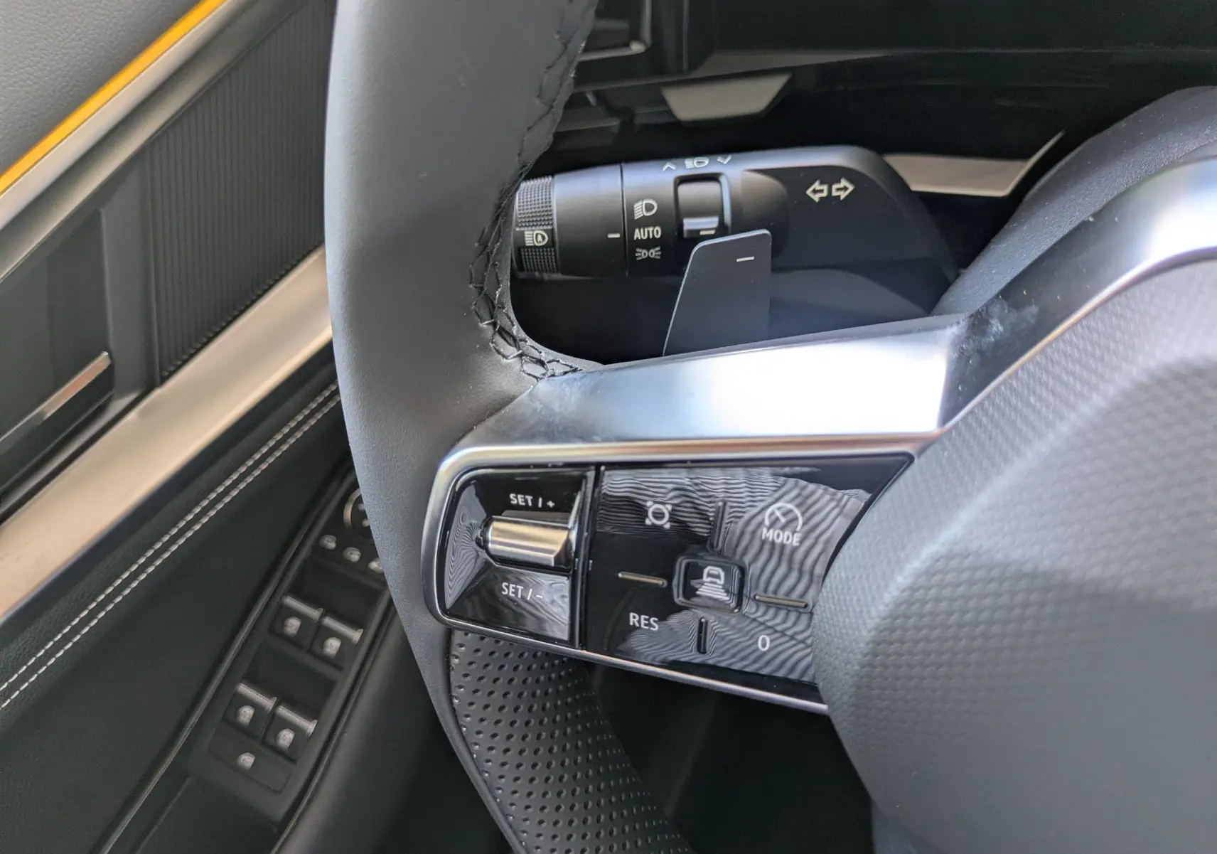 Gros plan sur les commandes de la planche de bord du Renault Austral E-Tech 200, boutons de parking et assistance visibles.