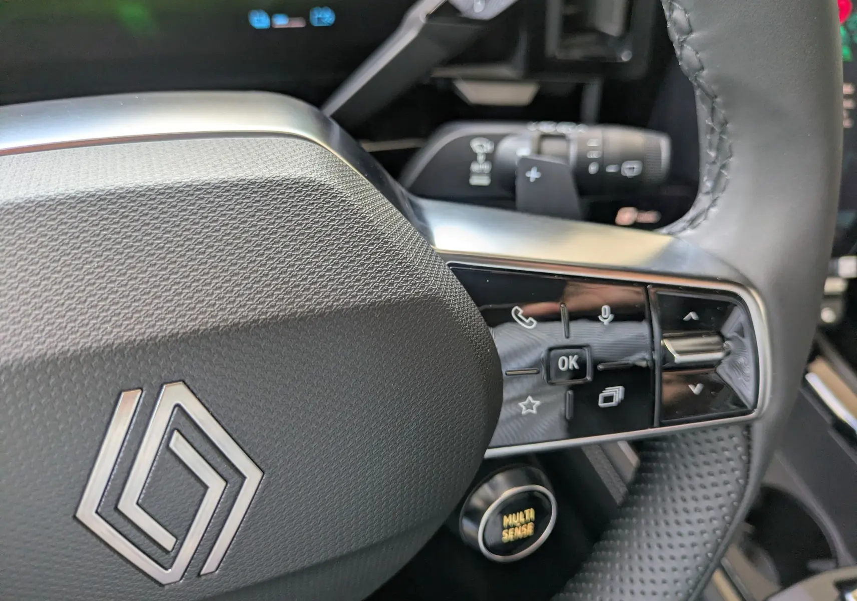 Gros plan sur les commandes gauche du volant du Renault Austral E-Tech 200 gris schiste, avec détails des boutons et levier.