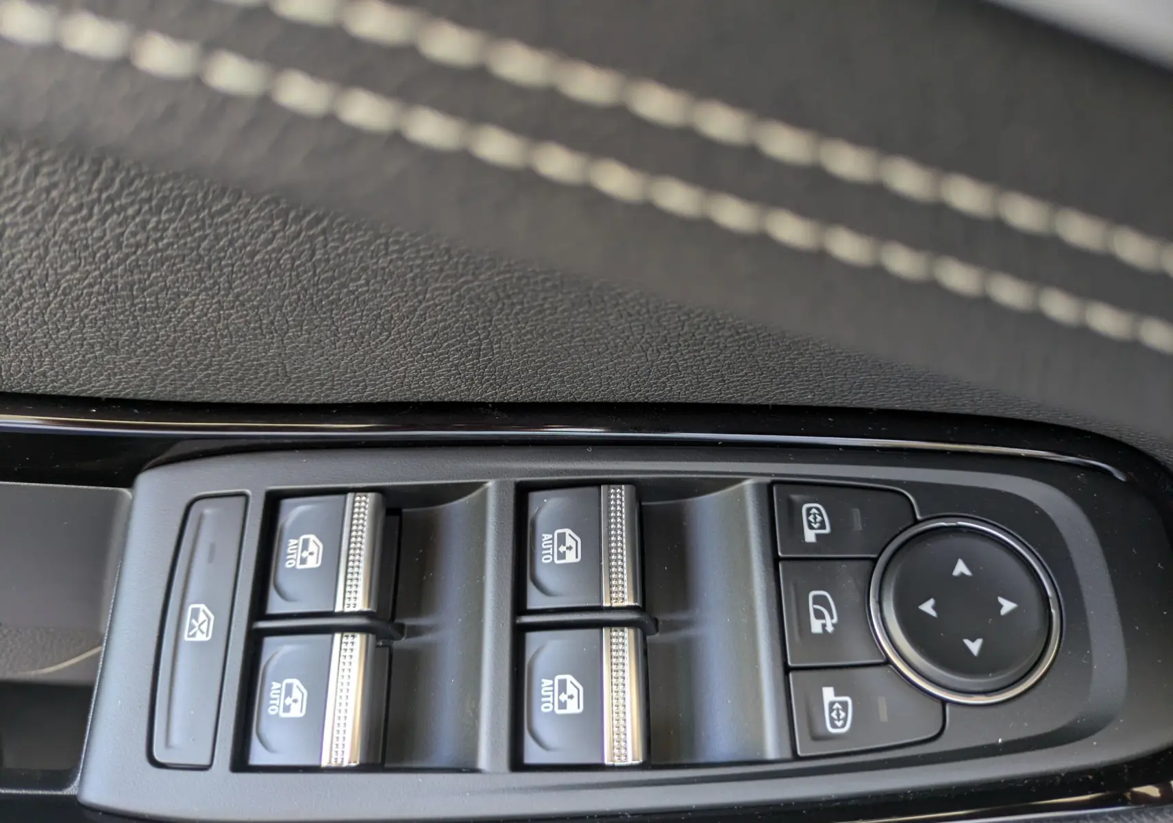 Gros plan sur les commandes des vitres électriques et rétroviseurs du Renault Austral E-Tech 200 Esprit Techno, intérieur noir.