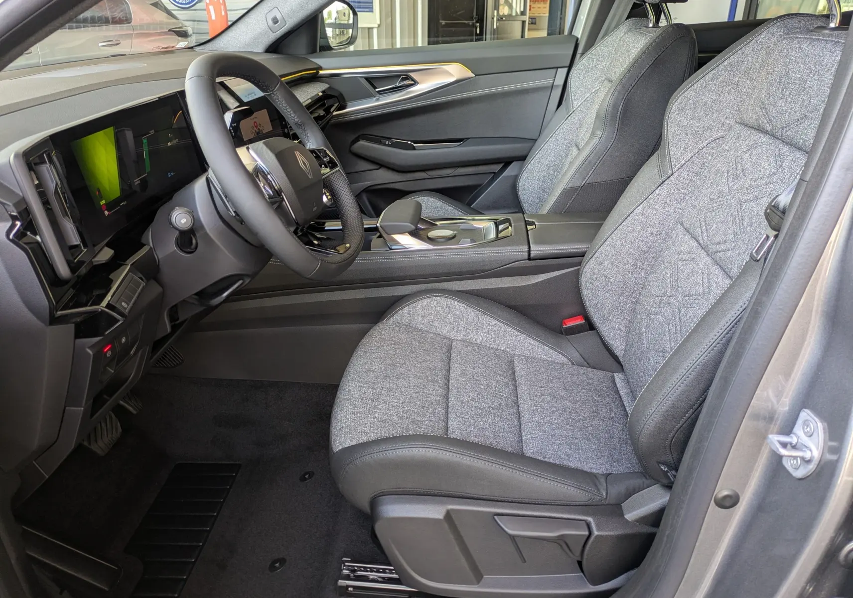 Vue intérieure du tableau de bord du Renault Austral E-Tech 200, avec volant multifonction et écran tactile vertical.