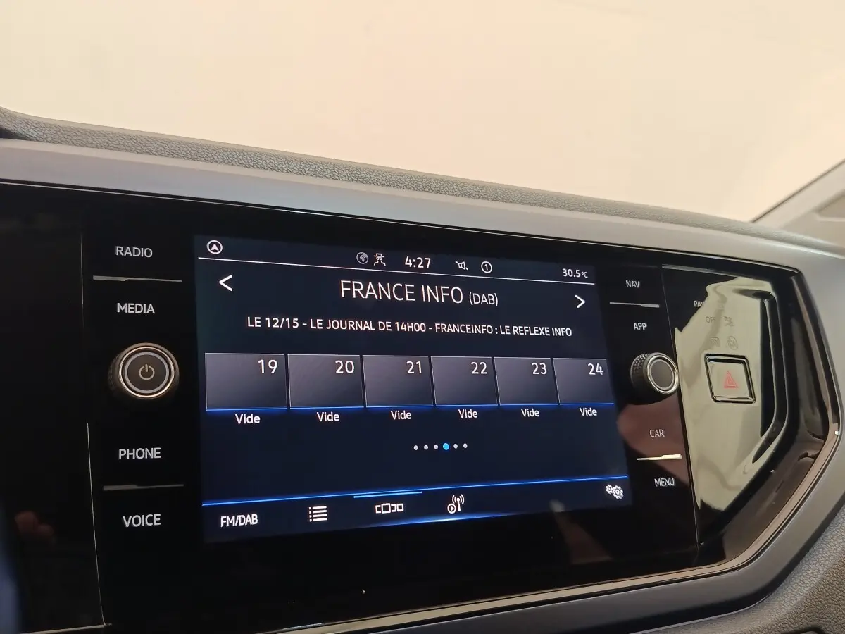 Écran tactile central de la Volkswagen Polo 1.0 TSI 95 United, affichage radio France Info, tableau de bord noir.