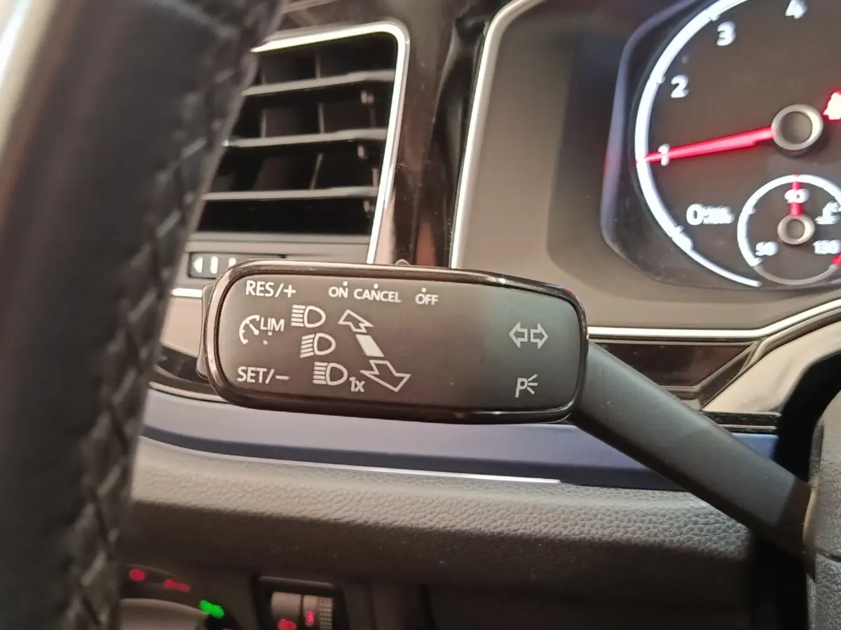 Gros plan sur la manette de commande multifonctions à gauche du volant dans le tableau de bord d'une Volkswagen Polo 1.0 TSI 95 United.