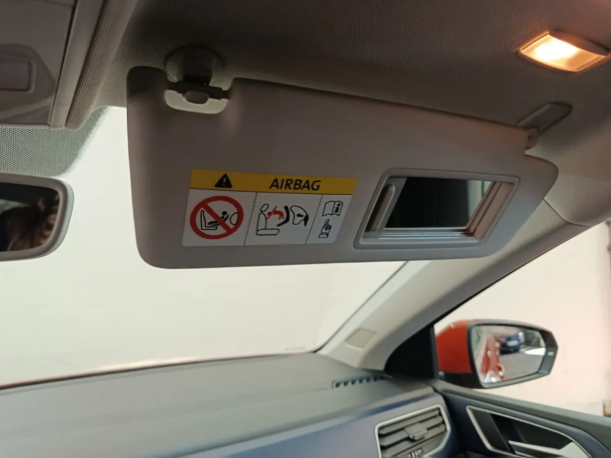 Intérieur Volkswagen Polo orange 2020, vue côté passager avec pare-soleil déplié et miroir intégré.
