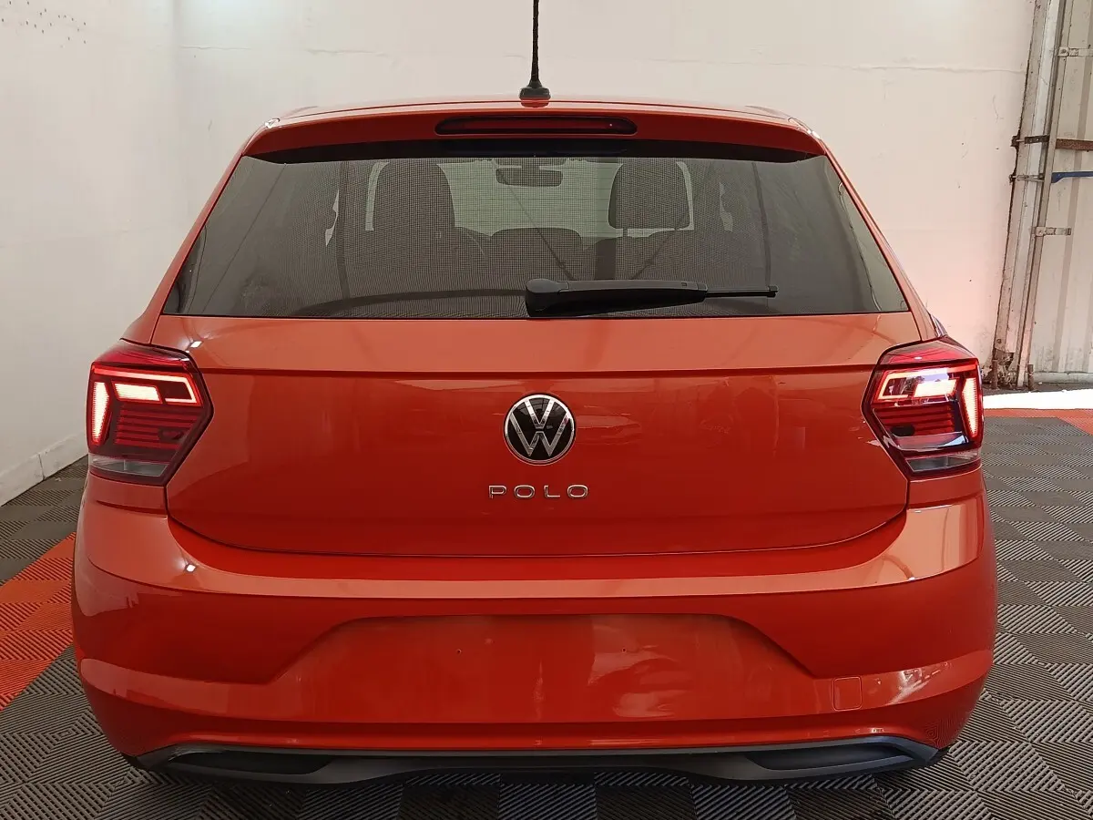 Vue arrière d'une Volkswagen Polo orange 2020 avec feux LED allumés dans un garage.