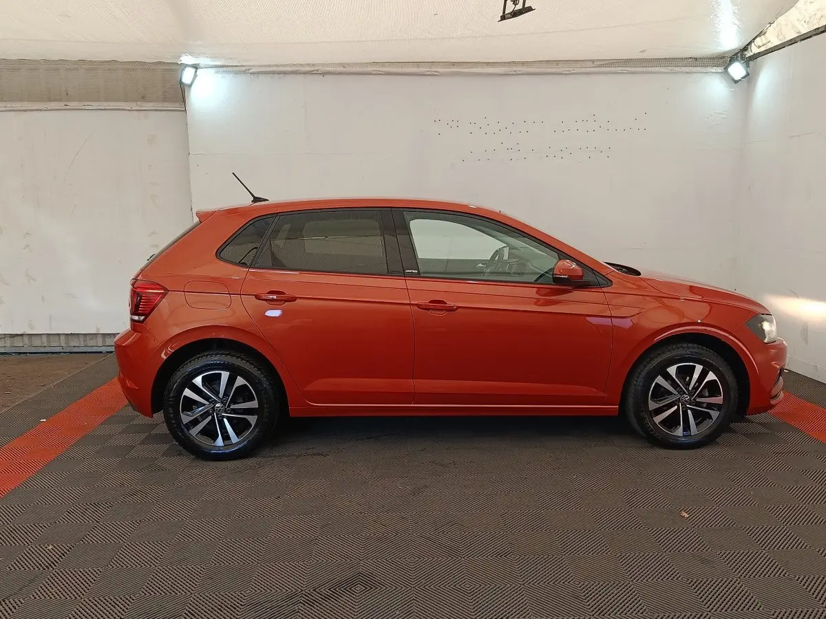 Profil droit d'une Volkswagen Polo 1.0 TSI 95 United orange, avec jantes alliage et vitres teintées, en intérieur neutre.