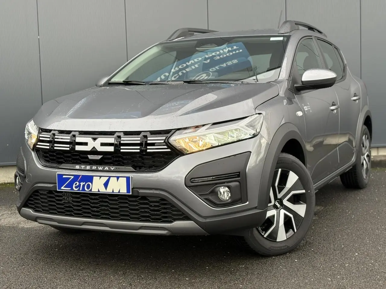 Dacia Sandero Stepway gris schiste en 3/4 avant droit avec calandre noire et jantes Atara Dark 16 pouces.