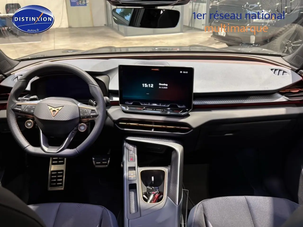 Vue intérieure avant du tableau de bord et volant noir du CUPRA TERRAMAR gris avec écran tactile central et console moderne.