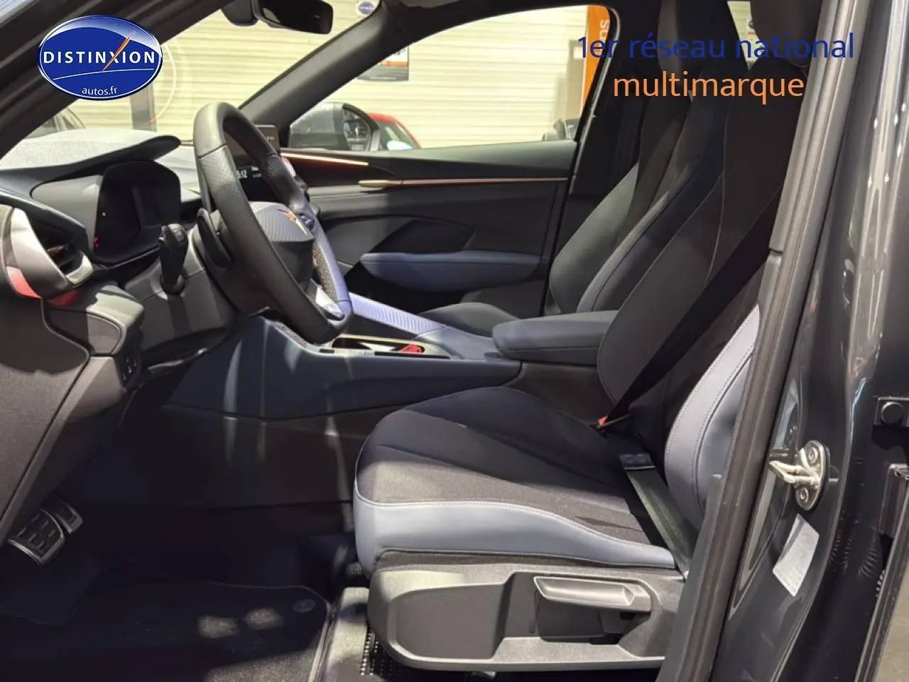 Intérieur avant droit de la CUPRA TERRAMAR gris 2025 avec sièges sport bicolores et volant cuir multifonction.