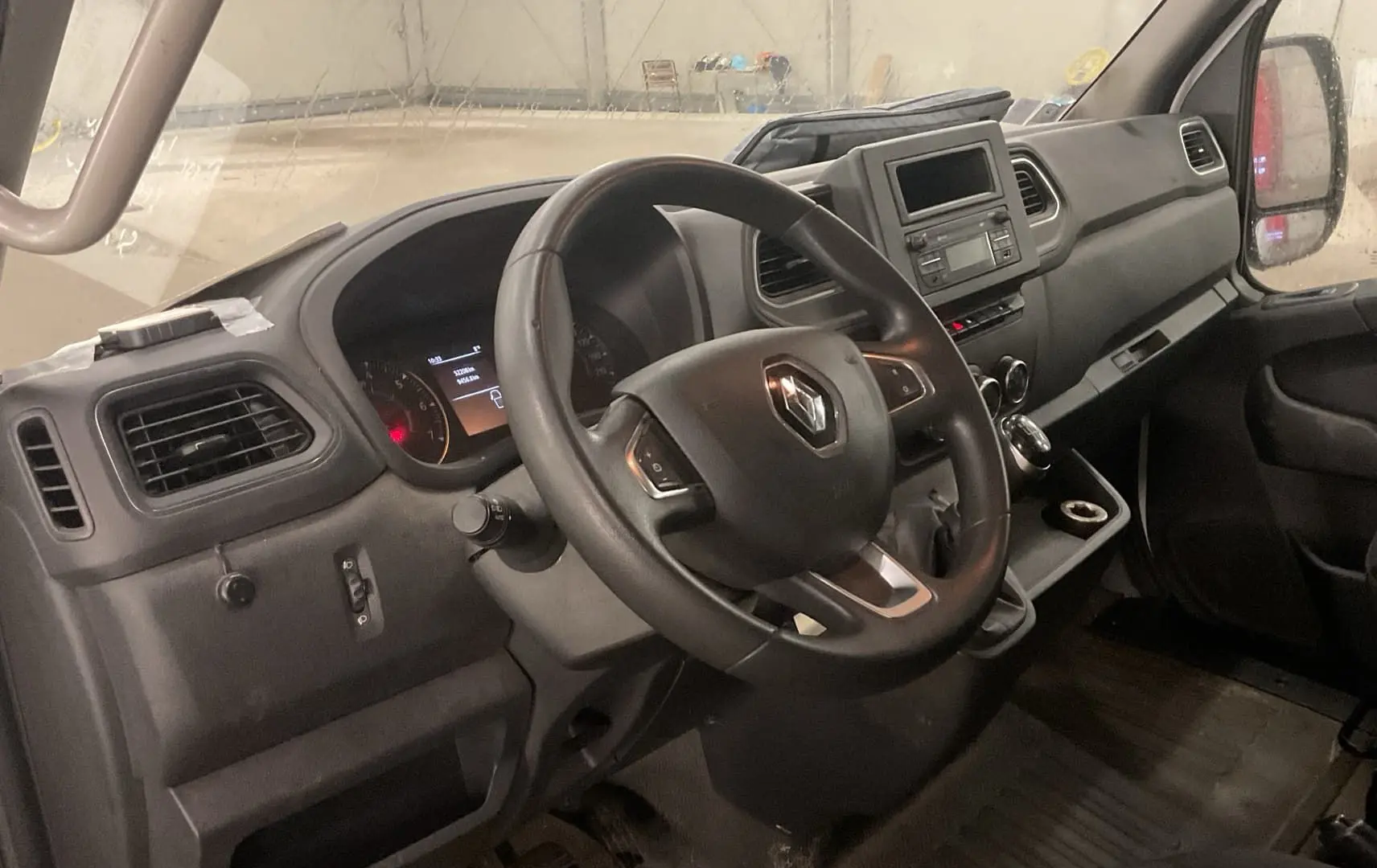 Vue intérieure côté conducteur du Renault Master Cabine Approfondie blanc, tableau de bord avec volant multifonction et écran central.