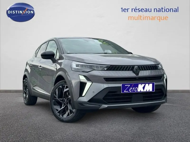 Renault Captur 1.8 E-Tech hybride 2026 gris Cassiopée/noir, vue 3/4 avant avec signature lumineuse distinctive.