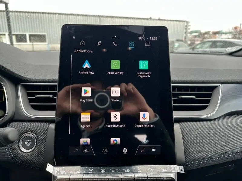 Vue intérieure centrée sur l'écran tactile du tableau de bord du Renault Captur 2026 gris Cassiopée/Noir Étoilé.