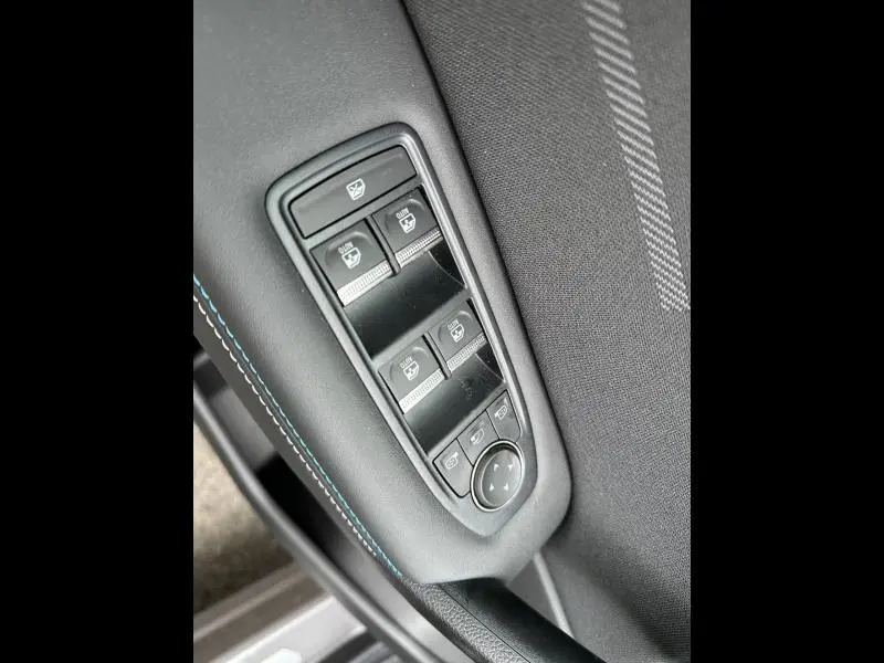 Gros plan sur les commandes des vitres électriques et réglages des rétroviseurs côté gauche du Renault Captur Gris Cassiopée/Noir Étoilé.