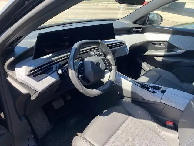 Vue intérieure côté conducteur du Peugeot 3008 2024 noir, mettant en valeur le tableau de bord numérique et le volant compact.