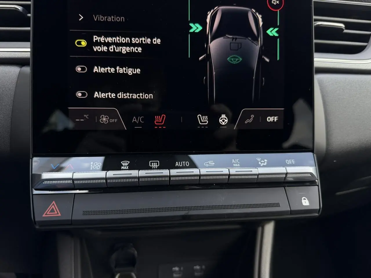 Vue rapprochée de l’écran tactile et des commandes de climatisation du Renault Captur noir étoile, affichant les alertes de sécurité.