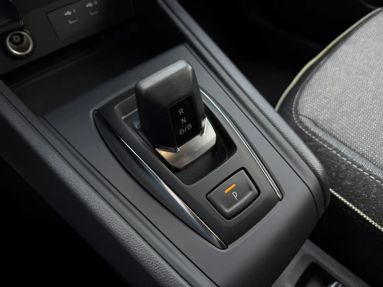 Gros plan sur la console centrale du Renault Captur 2026, levier de vitesses automatique et bouton de parking électronique.