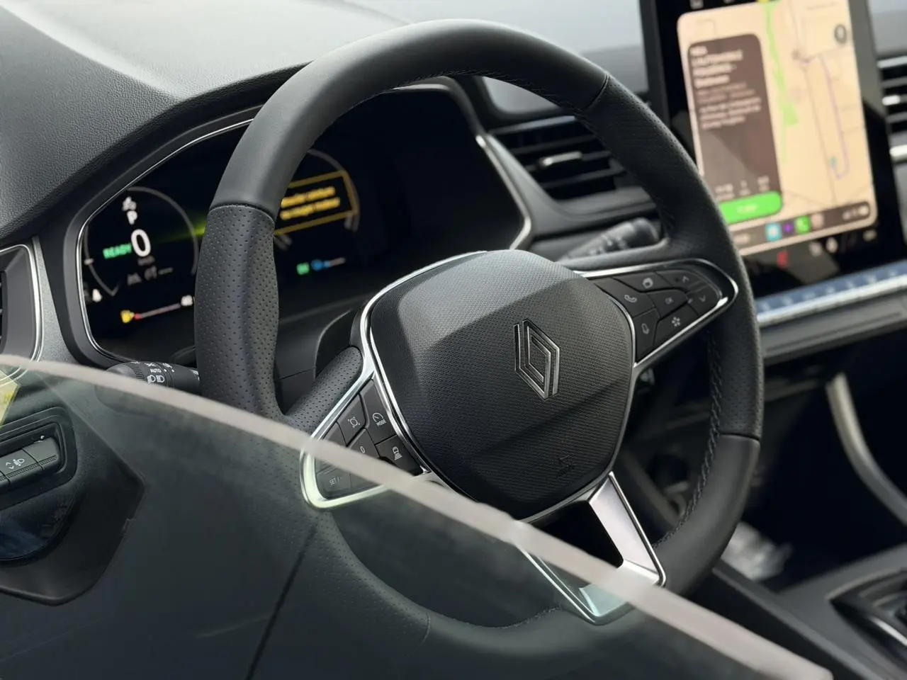 Gros plan sur le volant noir texturé du Renault Captur 2026 avec tableau de bord numérique et écran tactile.