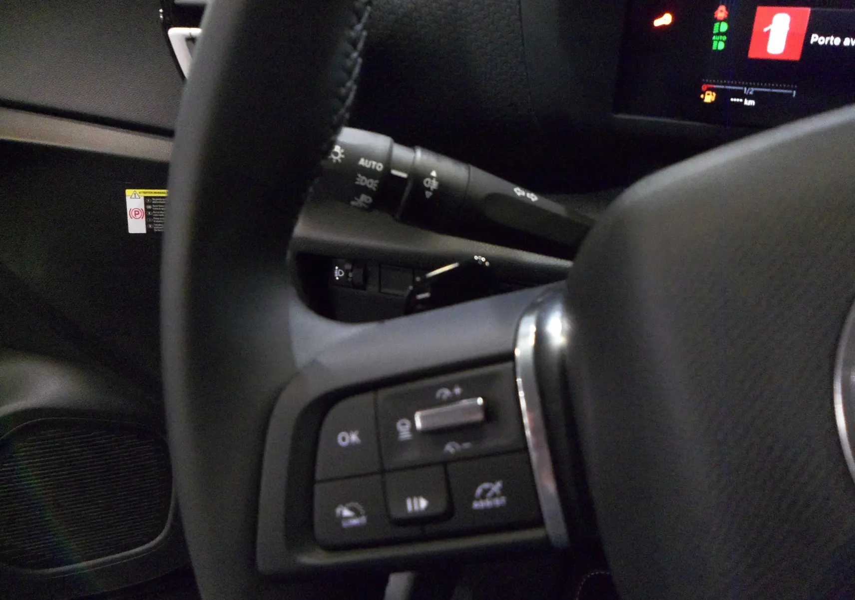Gros plan sur le volant et les commandes multifonctions côté gauche du tableau de bord d'une Citroën C4 Hybride 2025.