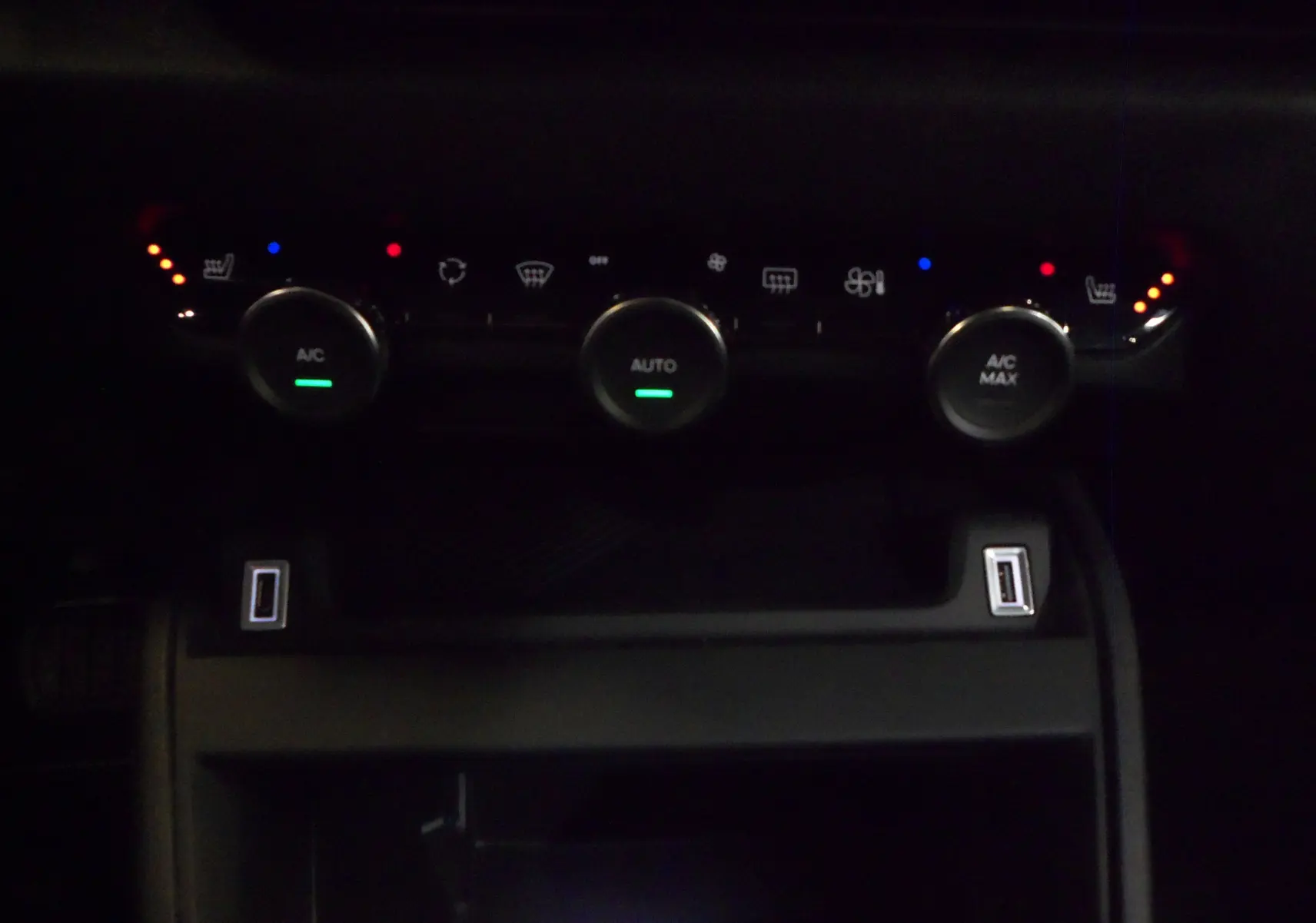 Gros plan sur la console centrale du Citroën C4 Hybride 136 e-DCS6 Max 2025, avec commandes climatisation et ports USB.